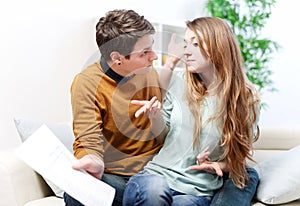 Young anxious couple quarrels by consulting their bank account