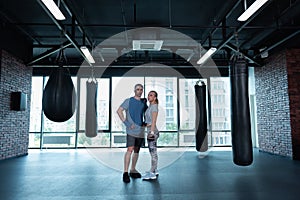 Young appealing athletic couple training together in gym