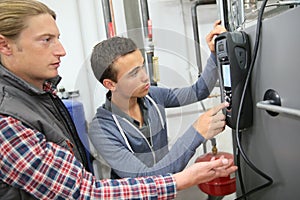 Young apprentice controlling machinery electronics