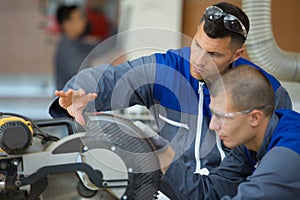 young apprentice learning to use circular saw