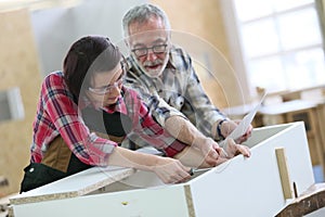 Young apprentice with senior craftsman of carpentry