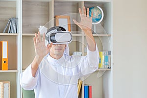 Young arab business man smiling while experiencing new visual sensations through the virtual reality headset in office