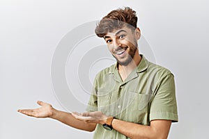 Young arab doctor man standing over isolated background inviting to enter smiling natural with open hand