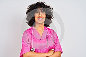 Young arab doctor woman with curly hair wearing stethoscope over isolated white background happy face smiling with crossed arms