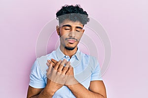 Young arab handsome man wearing casual clothes smiling with hands on chest, eyes closed with grateful gesture on face