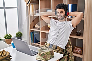 Young arab man army soldier using laptop and headphones at home