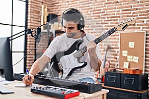 Young arab man artist compose song playing electrical guitar at music studio