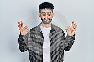 Young arab man with beard wearing glasses relax and smiling with eyes closed doing meditation gesture with fingers