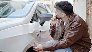 Young arab man looking crash car at street