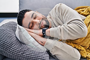 Young arab man lying on sofa sleeping at home