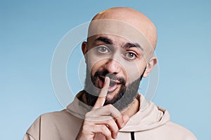 Young arab man making shh gesture