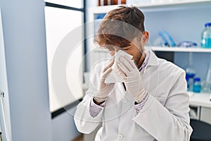 Young arab man scientist using napkin at laboratory