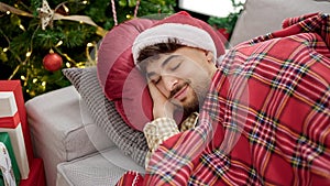 Young arab man sleeping on the sofa at christmas at home