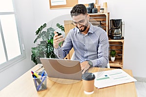 Young arab man smiling confident having video call working at office