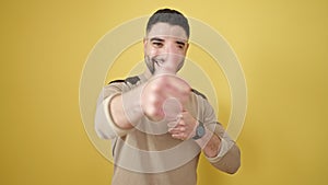 Young arab man smiling with thumbs up over isolated yellow background