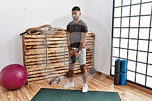 Young arab man training with kettlebell at sport center