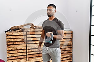 Young arab man training with kettlebell at sport center