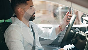 Young arab man using smartphone sitting on car at street