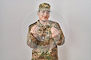 Young arab man wearing camouflage army uniform doing money gesture with hands, asking for salary payment, millionaire business