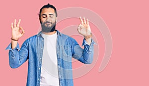 Young arab man wearing casual denim shirt relax and smiling with eyes closed doing meditation gesture with fingers