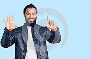 Young arab man wearing casual leather jacket showing and pointing up with fingers number seven while smiling confident and happy