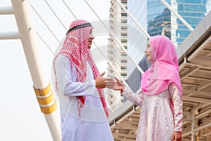 Young Arab Middle Eastern man and woman shaking hands in greetings, friendly meeting