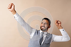 Young arab successful man celebrating triumph in studio