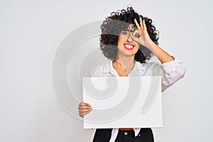 Young arab woman with curly hair holding banner over isolated white background with happy face smiling doing ok sign with hand on