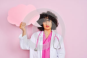 Young arab woman with curly hair holding cloud speech bubble over isolated pink background with a confident expression on smart