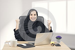 Young Arabian businesswoman expressing success at office