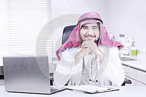 Young Arabian doctor smiling at workplace