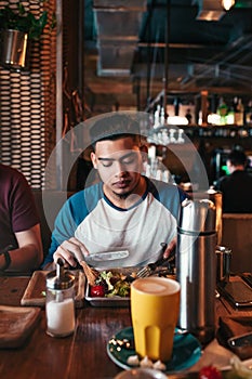 Young arabian man with his friends having breakfast in cafe.