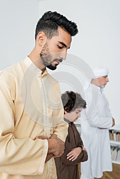 Young arabian man praying near blurred