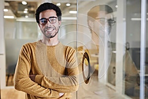 Young Arabian man wearing glasses in office and smiling at camera