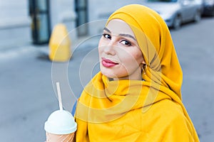 Young arabian muslim woman enjoying cocktail outdoor.