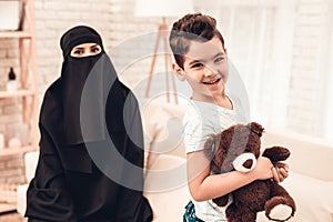 Young Arabian Woman with Smiling Son at Home.
