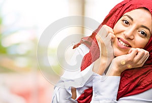 Young arabian woman wearing hijab isolated over natural background