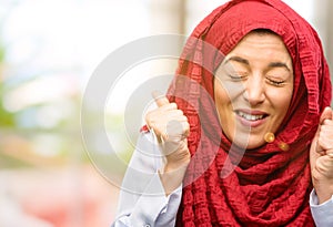 Young arabian woman wearing hijab over natural background
