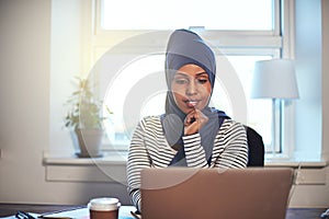 Young Arabic female entrepreneur working at home on a laptop