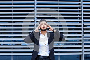 Young arabic man shows neck pain tired in business center