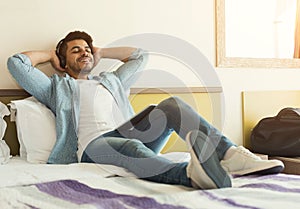 Young arabic man traveller lying on bed and relaxing