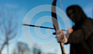 Young archer holding hes traditional hungarian bow, shallow depth of field, space for text