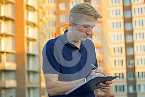 Young architect or engineer checking a building plan on site