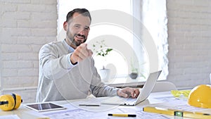 Young Architect with Laptop Pointing at Camera in Office