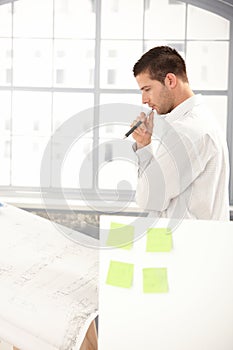 Young architect planning on paper in office