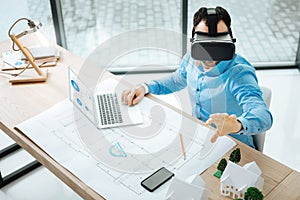 Young architect in VR headset working on his project