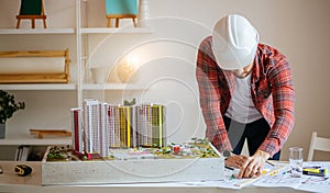 Young architect working with blueprints in office