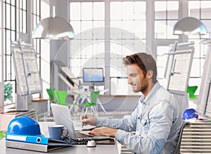 Young architect working at office desk