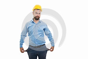 Young architect with yellow helmet showing empty pockets gesture
