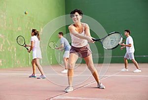 Young Argentinian woman playing frontenis at open-air fronton in summer